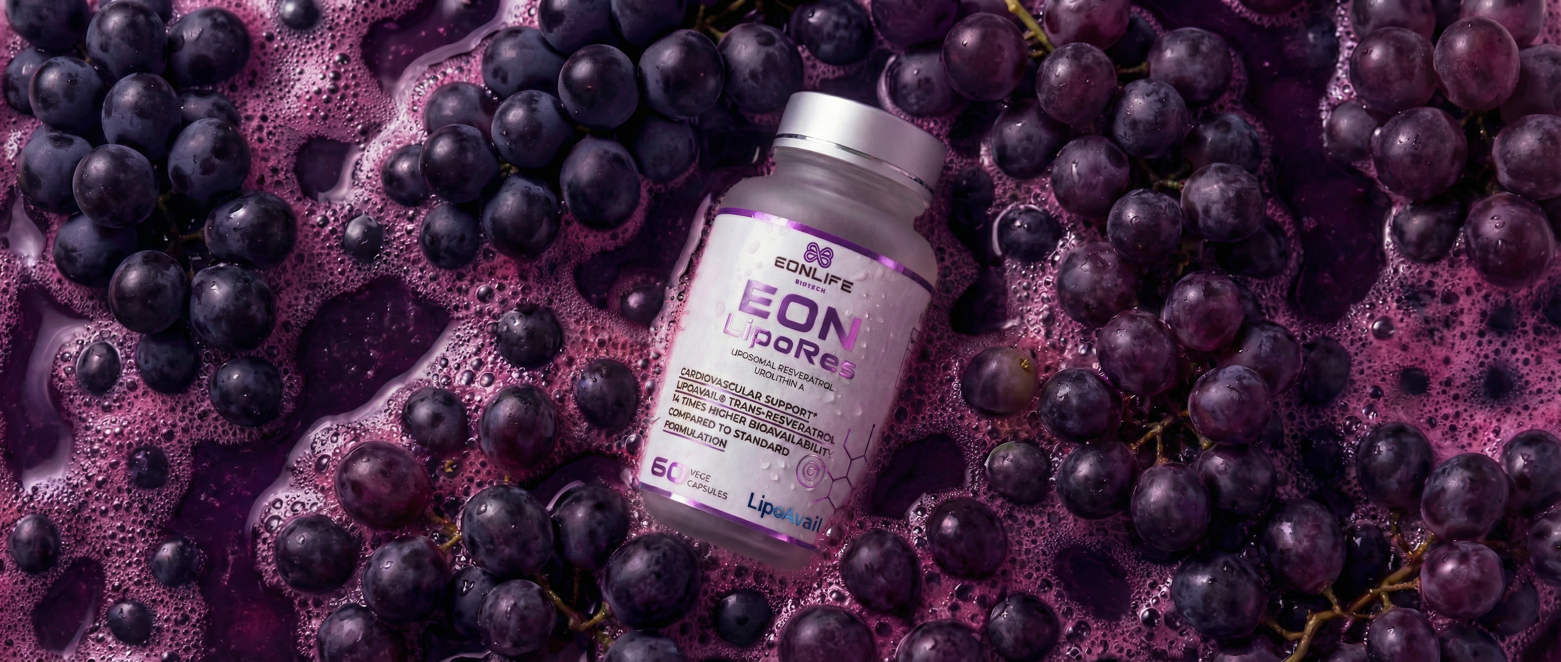 Na grafice przedstawiono suplement diety EON LipoRes marki EONLIFE Biotech umieszczony pośród ciemnych winogron zanurzonych w intensywnie fioletowym soku z widoczną pianą i kroplami wody.